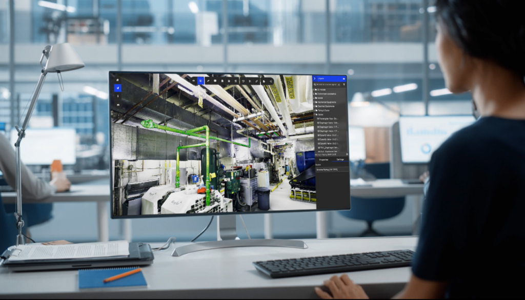 Engineer reviewing industrial facility data in 3D on Prevu3D platform at office workstation.