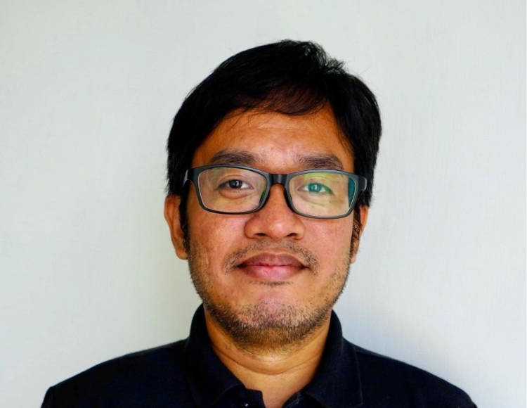 Portrait of Edward Ellema wearing glasses and a black shirt, facing forward against a light background.