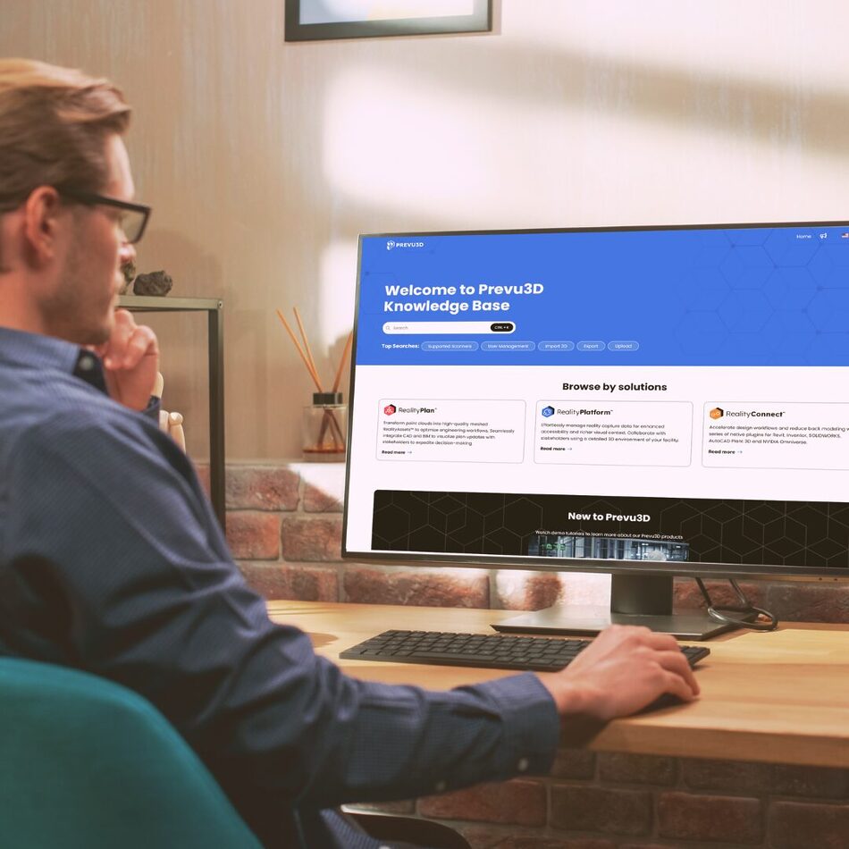 Man reading the Prevu3D Knowledge Base on a desktop computer in a home office.