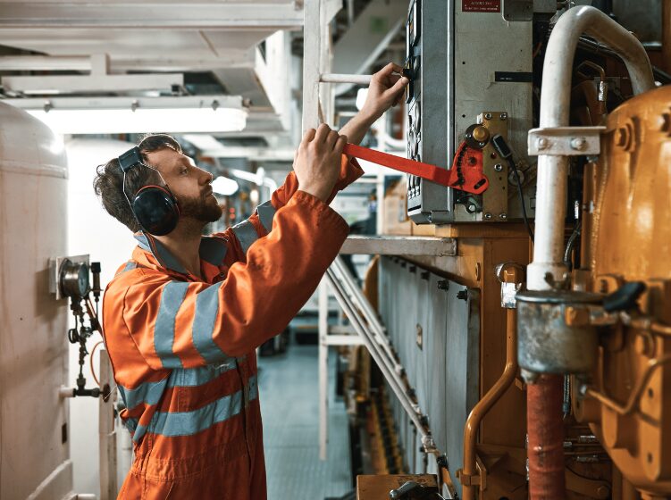 Marine engineer performing maintenance inside a vessel engine room, representing onboard operations supported by digital twin workflows.