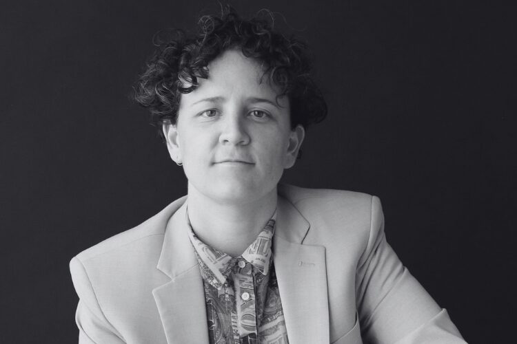 Elle Magni – Prevu3D Content Marketing Manager Headshot - Prevu3D Black-and-white headshot of Elle Magni, Content Marketing Manager at Prevu3D, seated and facing the camera against a dark background.