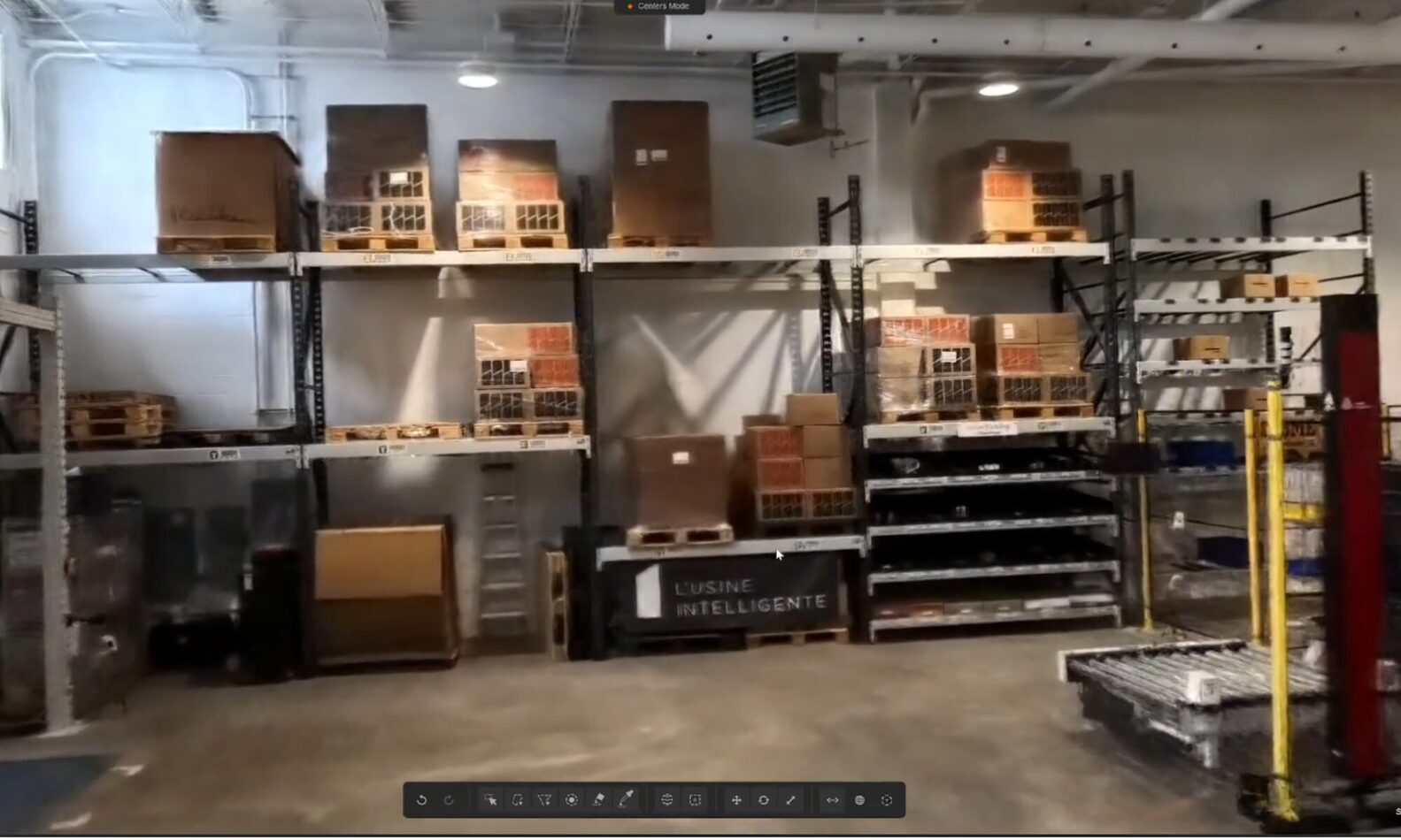 360 3d enviroment | prevu3d Warehouse storage area with tall metal shelving filled with cardboard boxes and pallets, labeled aisles, and a banner reading 'L'USINE INTELLIGENTE' along the lower shelf.