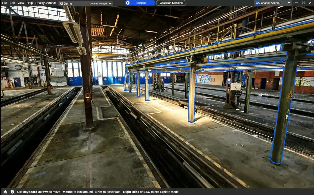 dbgaussian splattingasset selection | prevu3d Inside a large industrial rail yard/maintenance hall with multiple track pits, metal columns, and an overhead gantry; blue outlines mark suspended walkways and supports.