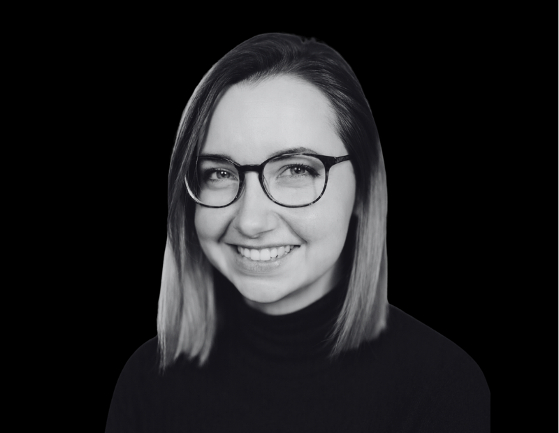 Andrea Burda | Prevu3d Professional Headshot of a Smiling Woman with Shoulder length Hair and Glasses Wearing a Black Turtleneck Against a Solid Black Background Prevu3d