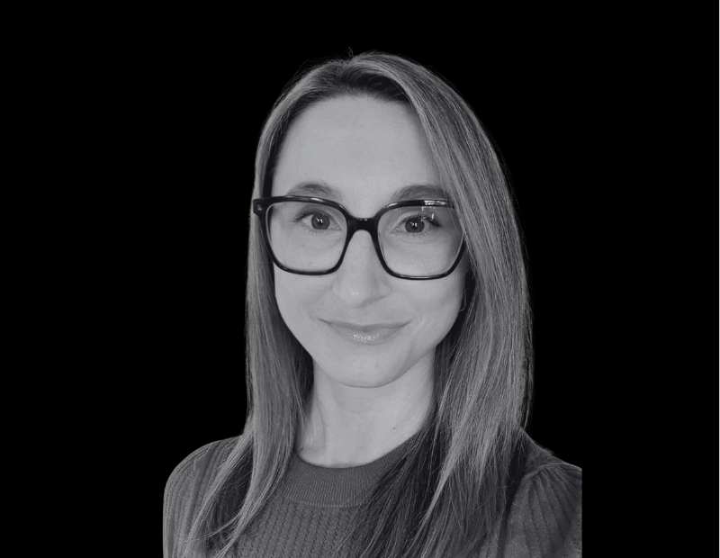 Smiling Woman with Long Hair and Large Black Glasses Gray toned Portrait Against a Black Background Prevu3d