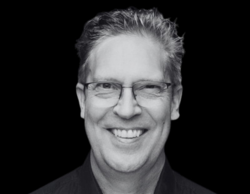 Michel Besner Ceo Prevu3d | Prevu3d Head and shoulders Black and white Portrait of a Smiling Man with Rectangular Glasses and Short Hair Against a Black Background Prevu3d